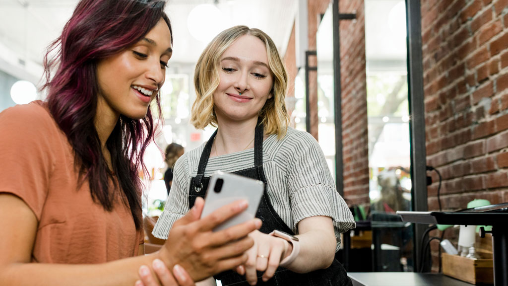 Stylists looking at a smartphone together